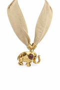 Collar de bisutería con cinta beige tipo malla y colgante de elefante dorado con cabujón granate, sobre fondo blanco