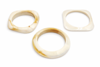 Pack de 3 pulseras rígidas de resina color marfil con vetas miel en diferentes formas, sobre fondo blanco