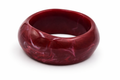 Pulsera rígida ancha de resina color burdeos marmoleado, sobre fondo blanco